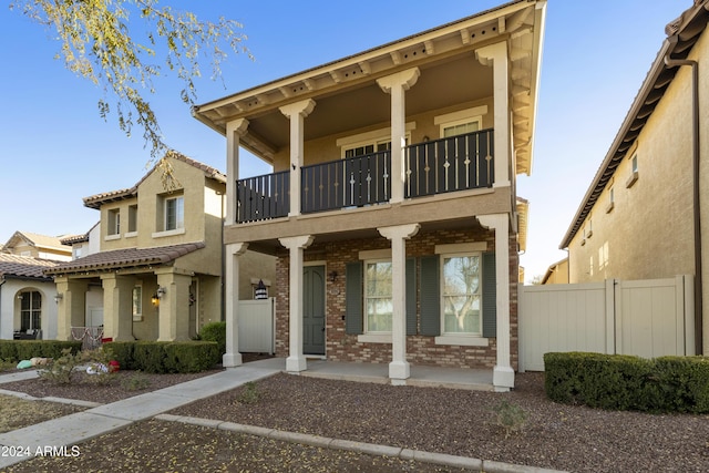 mediterranean / spanish house featuring a porch and a balcony