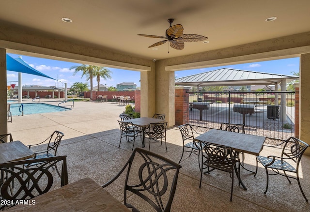 view of patio featuring a gazebo, ceiling fan, and a community pool