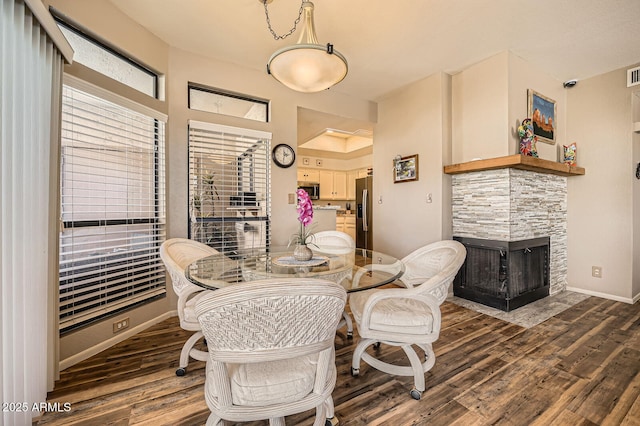 9707 E Mountain View Rd Unit 1408, Scottsdale, AZ 85258 - dining area with wood finished floors, a stone fireplace, and baseboards