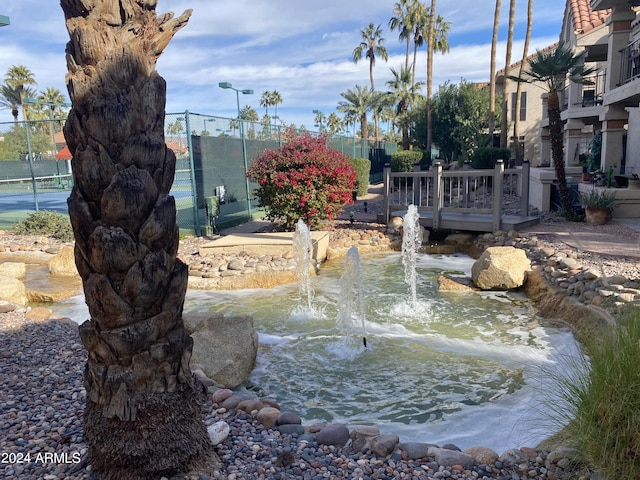 9707 E Mountain View Rd Unit 1408, Scottsdale, AZ 85258 - surrounding community with fence, a tennis court, and a small pond