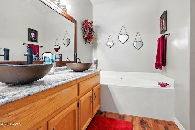 601 E Phoenix St, Payson, AZ 85541 - full bathroom featuring double vanity, a sink, a garden tub, and wood finished floors