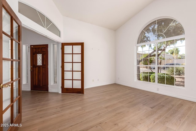 1213 W Beck Ln, Phoenix, AZ 85023 - unfurnished room featuring french doors, lofted ceiling, and light wood-type flooring