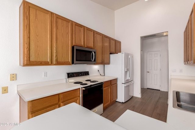1213 W Beck Ln, Phoenix, AZ 85023 - kitchen with white appliances, wood finished floors, light countertops, and brown cabinetry
