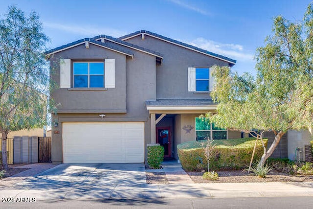 traditional-style home featuring stucco siding, a garage, concrete driveway, and fence