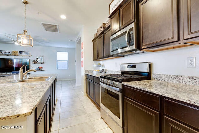 kitchen with light tile patterned floors, visible vents, a sink, dark brown cabinetry, and appliances with stainless steel finishes