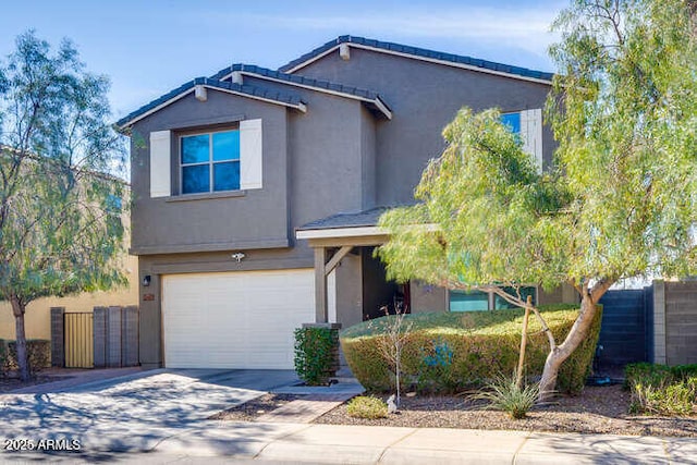 view of front of house featuring concrete driveway, fence, a garage, and stucco siding