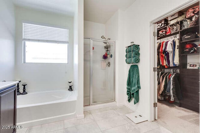 bathroom with a bath, a stall shower, and a spacious closet