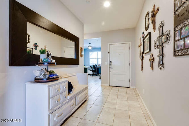 corridor with light tile patterned floors and baseboards