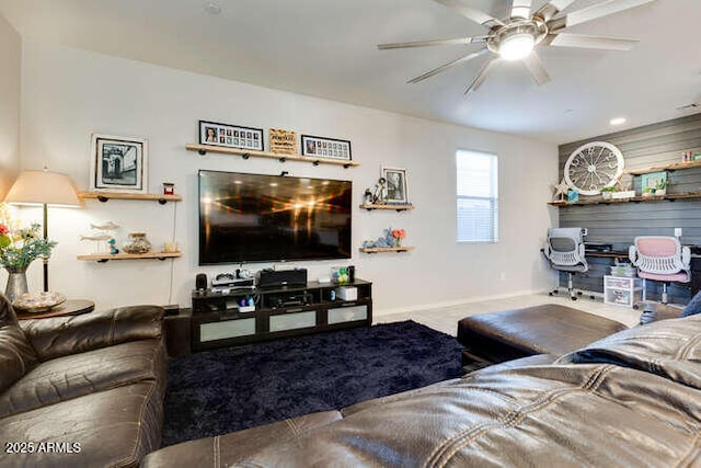 living area featuring carpet flooring, baseboards, and a ceiling fan