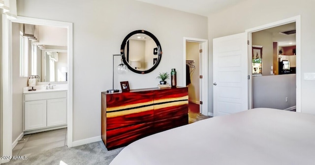 bedroom featuring light carpet and ensuite bath