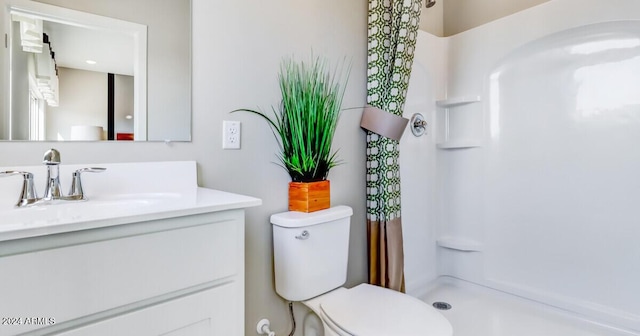 bathroom with a shower with shower curtain, vanity, and toilet