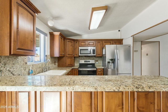 kitchen with lofted ceiling, stainless steel appliances, sink, and backsplash