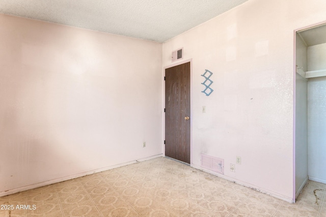 spare room with a textured ceiling