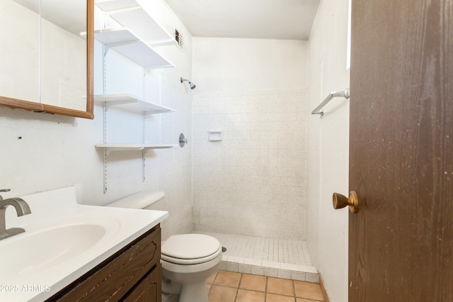 bathroom featuring tiled shower, vanity, toilet, and tile patterned floors