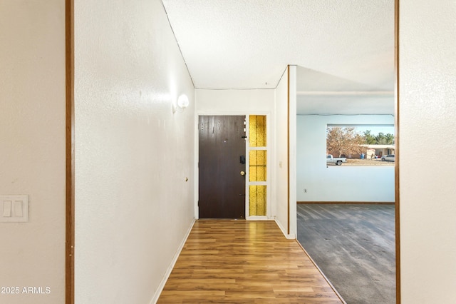 corridor featuring hardwood / wood-style floors and a textured ceiling