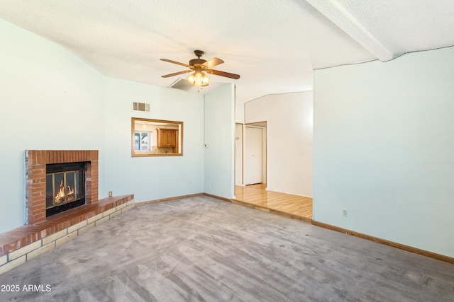 unfurnished living room featuring a fireplace, lofted ceiling with beams, a textured ceiling, and carpet