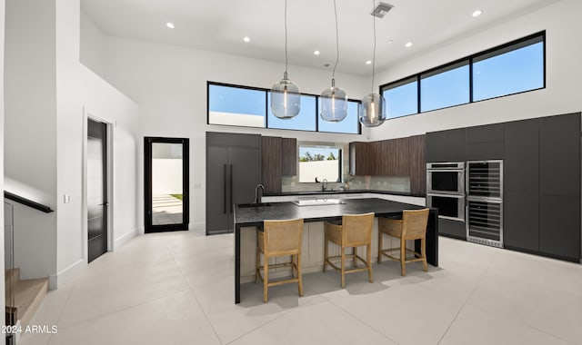 kitchen featuring a center island, a high ceiling, tasteful backsplash, and plenty of natural light