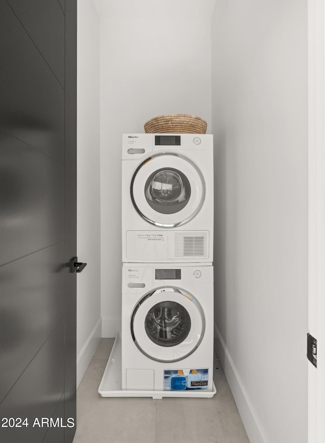 washroom featuring stacked washer / drying machine