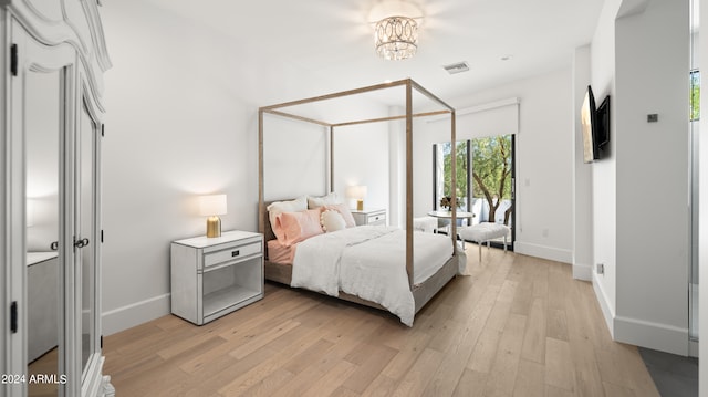 bedroom featuring light hardwood / wood-style floors and an inviting chandelier