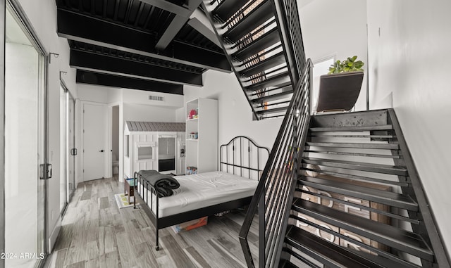 interior space featuring a towering ceiling and light hardwood / wood-style floors