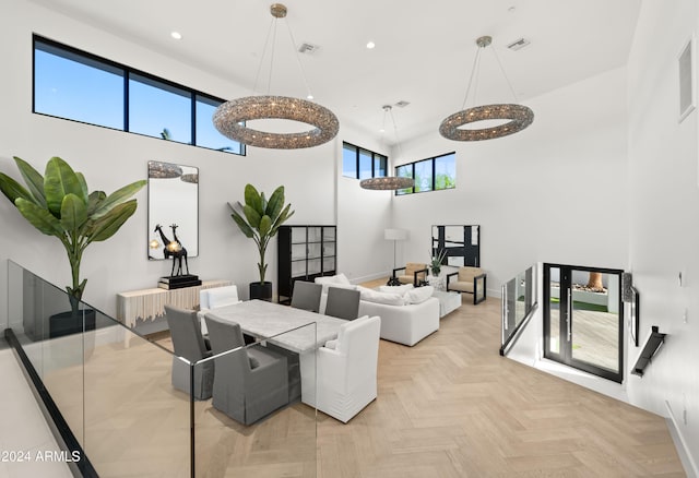 dining space featuring a high ceiling and light parquet floors