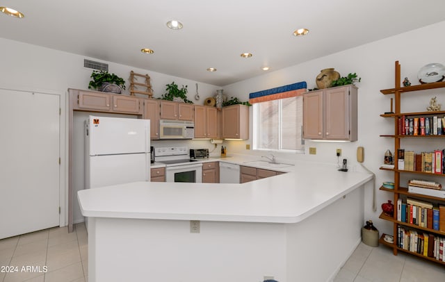 kitchen featuring light brown cabinets, white appliances, kitchen peninsula, and light tile patterned floors