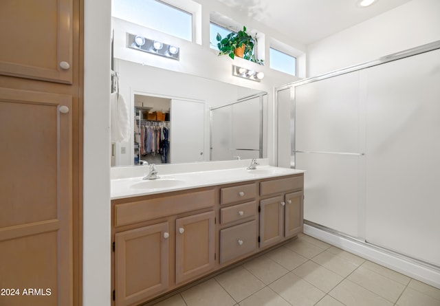 bathroom featuring tile patterned flooring, vanity, and a shower with door