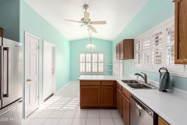 kitchen featuring sink, ceiling fan, stainless steel appliances, vaulted ceiling, and kitchen peninsula