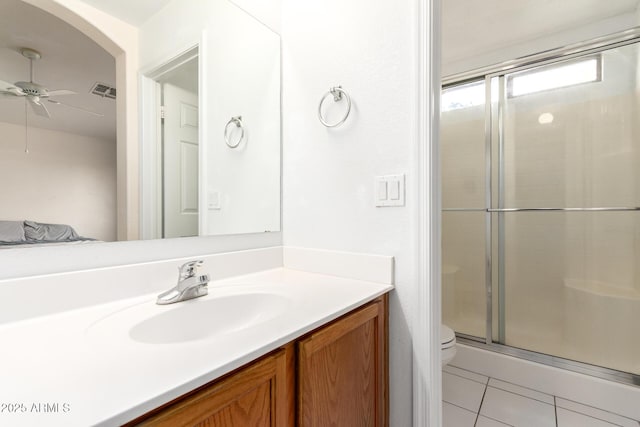 bathroom featuring ceiling fan, tile patterned flooring, vanity, toilet, and walk in shower