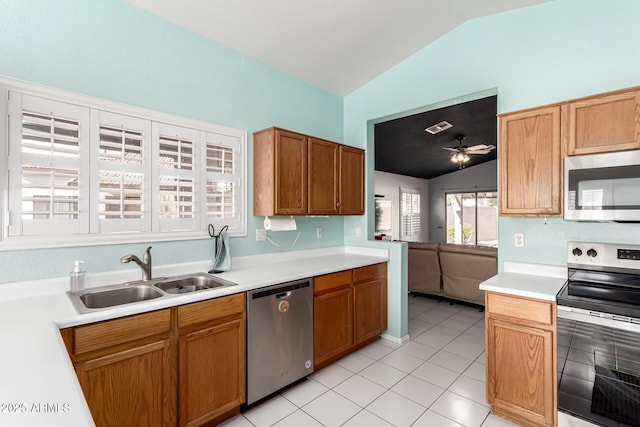 kitchen featuring lofted ceiling, sink, light tile patterned floors, ceiling fan, and appliances with stainless steel finishes