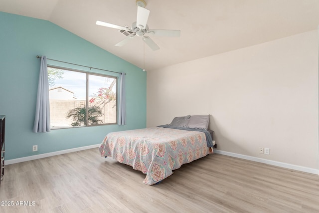 bedroom featuring ceiling fan, lofted ceiling, and light hardwood / wood-style flooring