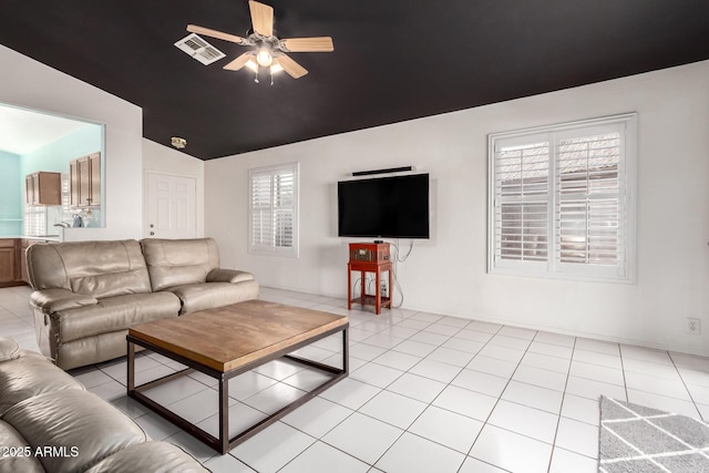 living room with ceiling fan, lofted ceiling, and light tile patterned floors