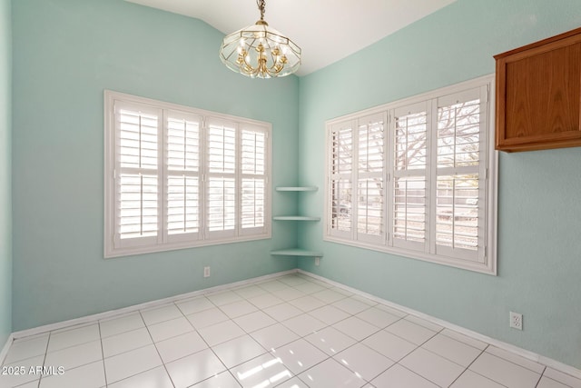 empty room with lofted ceiling and a notable chandelier