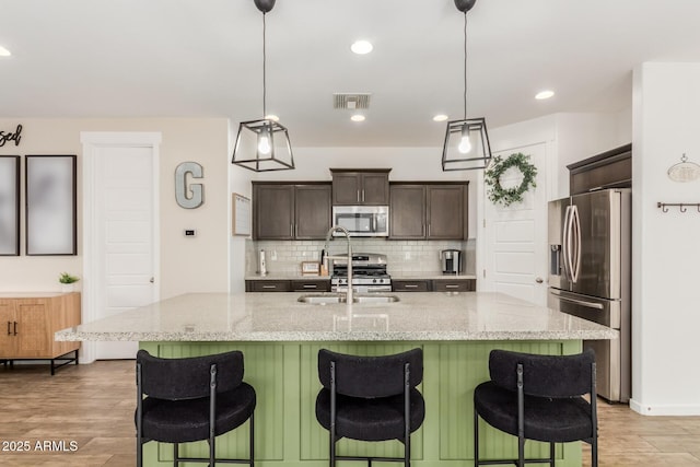 13380 N 148th Ave, Surprise, AZ 85379 - kitchen with appliances with stainless steel finishes, a sink, dark brown cabinets, backsplash, and light wood-type flooring