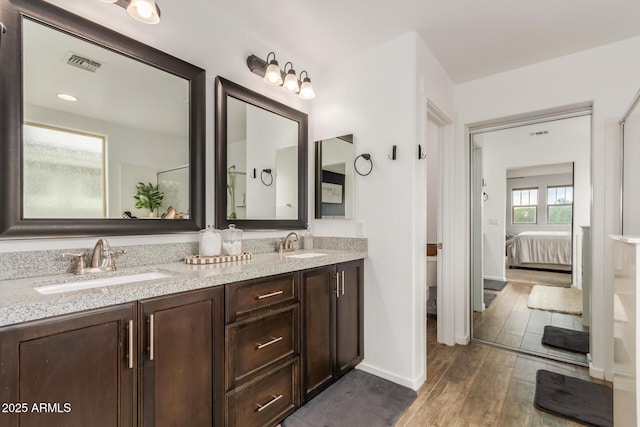 13380 N 148th Ave, Surprise, AZ 85379 - bathroom featuring wood finished floors, ensuite bath, double vanity, baseboards, and toilet