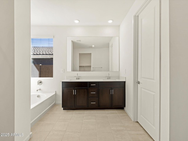 bathroom with tile patterned flooring, vanity, and a tub