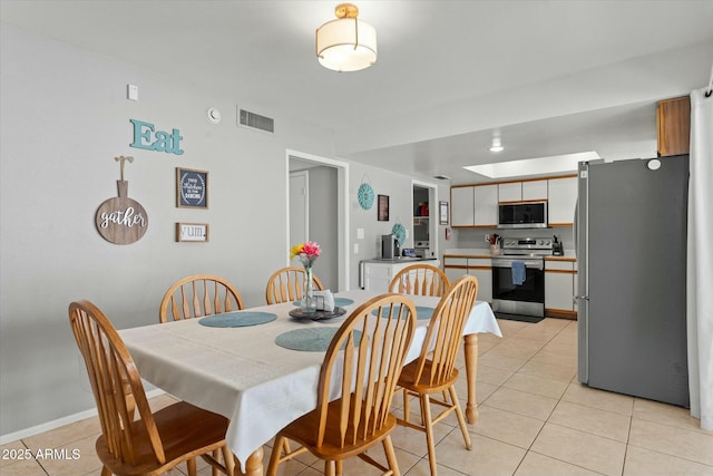 dining room featuring baseboards, visible vents, and light tile patterned floors
