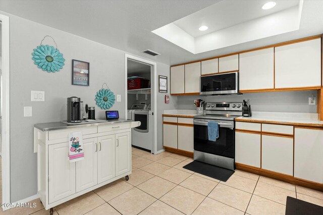 kitchen featuring light countertops, visible vents, appliances with stainless steel finishes, white cabinetry, and a tray ceiling
