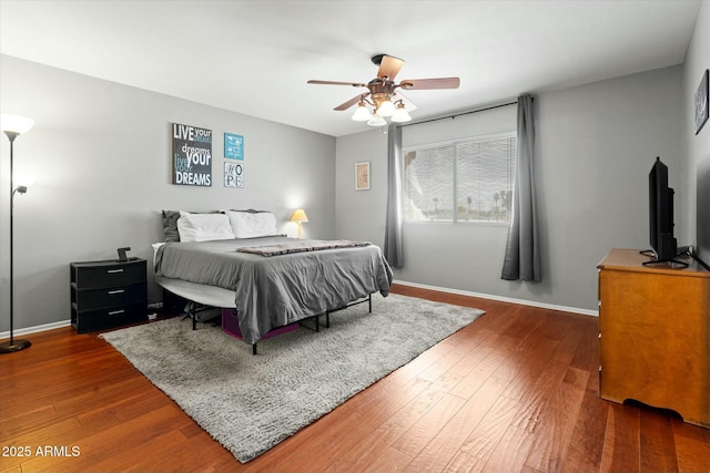 bedroom featuring dark wood-type flooring, ceiling fan, and baseboards