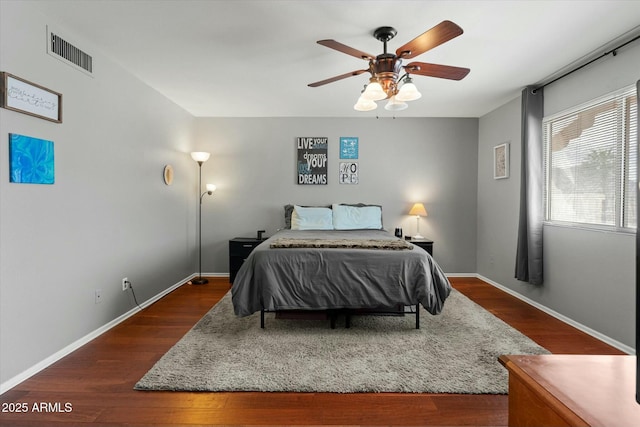 bedroom featuring a ceiling fan, dark wood-type flooring, baseboards, and visible vents