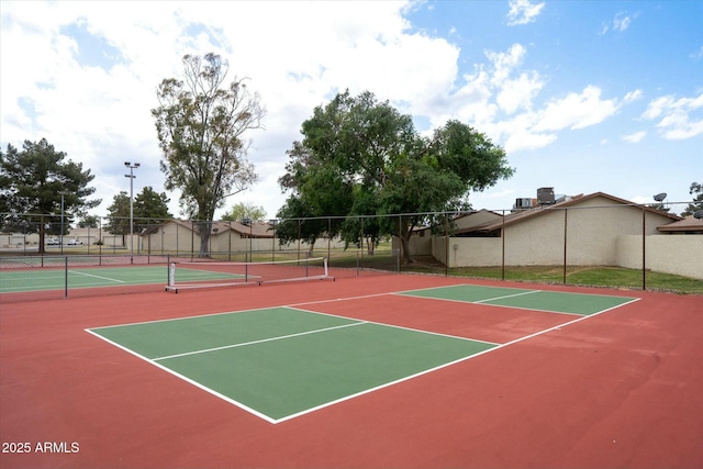 view of tennis court featuring fence and community basketball court