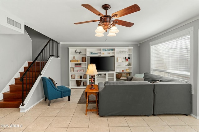 tiled living area with a ceiling fan, baseboards, stairs, and visible vents