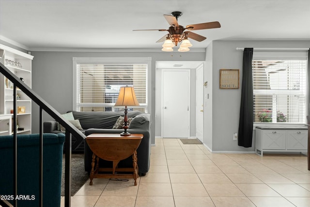 living area featuring baseboards, a ceiling fan, and light tile patterned floors