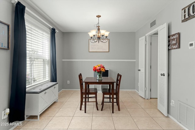 dining area featuring light tile patterned flooring, visible vents, and a chandelier