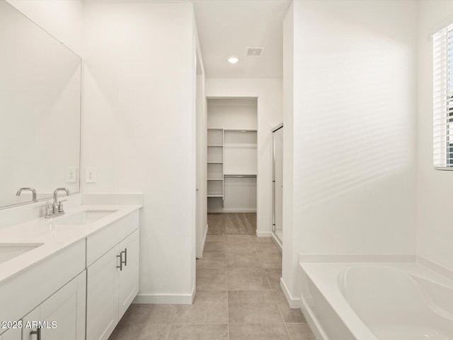 bathroom featuring a washtub, tile patterned floors, and vanity