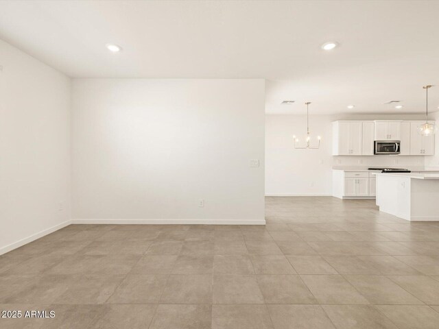 tiled empty room featuring a chandelier