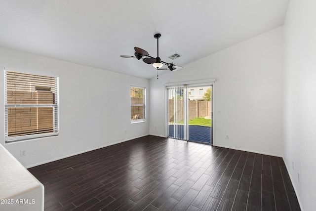 empty room with vaulted ceiling, ceiling fan, and dark hardwood / wood-style flooring