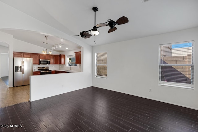 unfurnished living room featuring lofted ceiling, sink, dark hardwood / wood-style floors, and ceiling fan