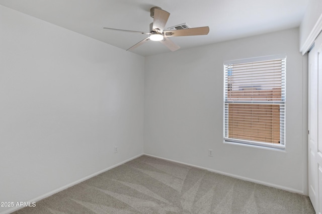 empty room with ceiling fan and light carpet