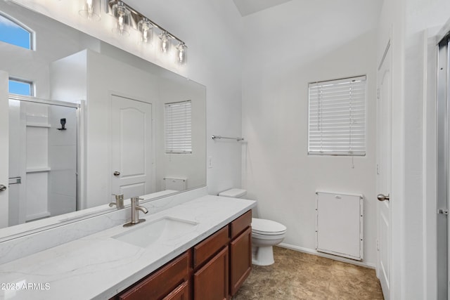 bathroom featuring vanity, toilet, and a shower with door